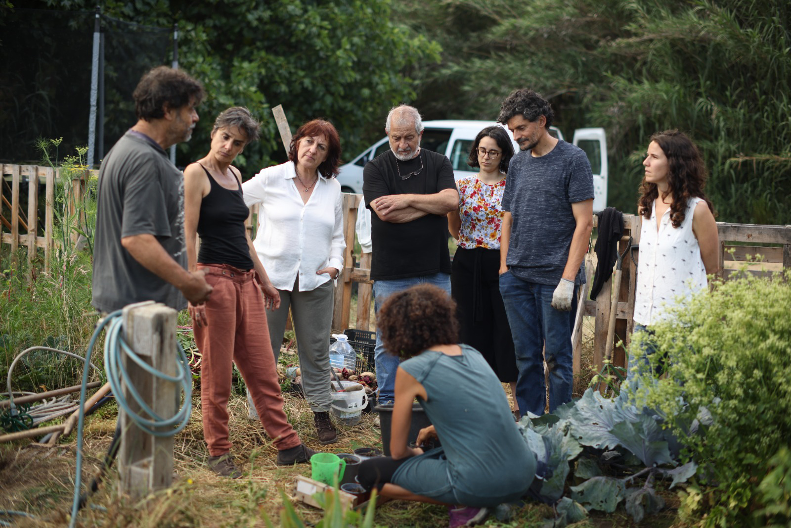 Un grup de persones aprenen sobre el procés de creixement de les plantes i la funció de l'humus